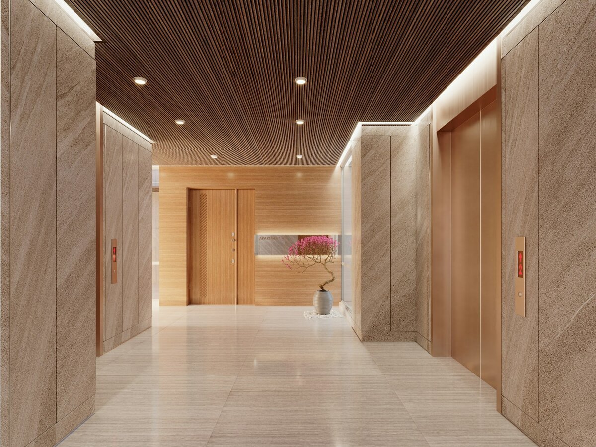 Modern shared building lobby with lift doors, marble walls, timber accents and soft lighting.